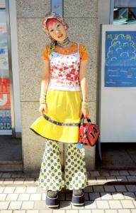 Asian girl wearing a yellow skirt, holding a red purse